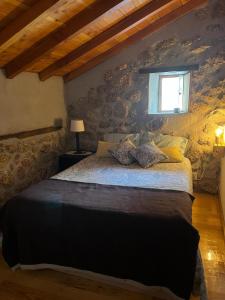 um quarto com uma cama grande e uma janela em Casa da Serra da Estrela em Gonçalo