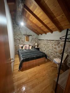 um quarto com uma cama e piso em madeira em Casa da Serra da Estrela em Gonçalo