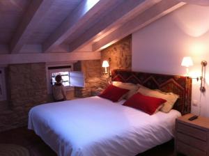 a hotel room with a large bed and a large window at Hotel El Cerco in Puente la Reina