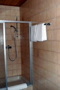 La salle de bains est pourvue d'une douche avec une porte en verre. dans l'établissement Gästehaus Vis-A-Vis, à Rüdesheim am Rhein