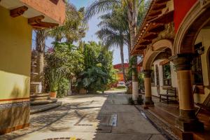 an alley with palm trees and a building at Hotel Villas San Miguel in Pátzcuaro
