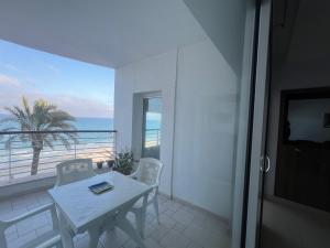 einen weißen Tisch und Stühle auf einem Balkon mit Meerblick in der Unterkunft Mahdia avec vue sur mer 3 in Hiboun