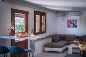 een woonkamer met een tafel en een bank bij Poolside compact family cottage Lea in Rovinjsko Selo