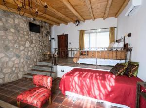 a bedroom with a red bed and a balcony at Tantasiña Cabañas Suites de Montaña in San Javier