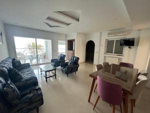 ein Wohnzimmer mit einem Sofa, Stühlen und einem Tisch in der Unterkunft Mahdia avec vue sur mer 3 in Hiboun