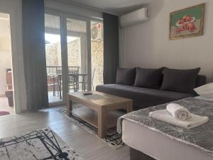 ein Wohnzimmer mit einem Sofa und einem Tisch in der Unterkunft Cuprija _apartments in Stolac