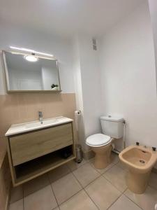ein Badezimmer mit einem WC, einem Waschbecken und einem Spiegel in der Unterkunft Appart 5 min à pied de la plage in Cap d'Agde