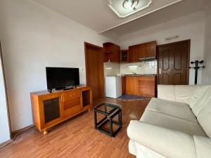a living room with a couch and a flat screen tv at Villa KiWi in the Heart of Ohrid in Ohrid