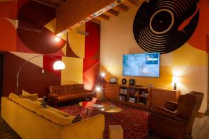 un soggiorno con divano e TV a schermo piatto di Big Sky Hotel a Chamonix-Mont-Blanc