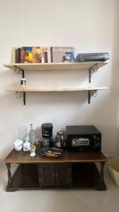 une table avec un four micro-ondes et une étagère avec des livres dans l'établissement Hanaia House, à Stone Town
