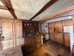 an old kitchen with wooden cabinets and a ceiling at Gîte de l'Ortenbourg - mobilier d antiquaire in Scherwiller