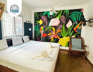 a bedroom with a large bed with a colorful wall at Bayahibe Village Inn in Bayahibe