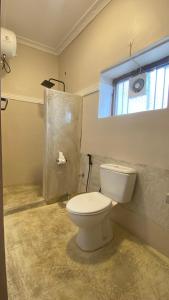 ein Bad mit einem weißen WC und einem Fenster in der Unterkunft Hanaia House in Stone Town