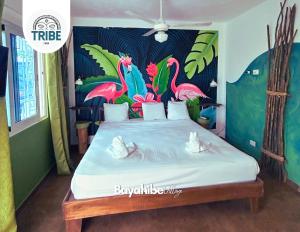 ein Schlafzimmer mit einem Bett mit einem Flamingos-Gemälde in der Unterkunft Bayahibe Village Inn in Bayahibe