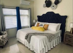 a bedroom with a bed with a blue headboard and pillows at Just like home Vacation in Ocho Rios