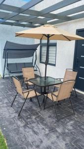 a table and chairs with an umbrella on a patio at Just like home Vacation in Ocho Rios