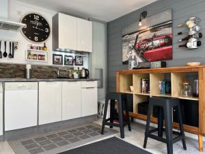 a kitchen with white cabinets and black stools at Living at Saarpartments - Business & Holiday Apartments with Netflix for Long- and Short term Stay, 3 min to St Johanner Markt and Points of Interest in Saarbrücken