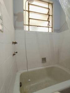 Studio Niterói-Barcas 604 في نيتيروي: حوض استحمام في الحمام مع نافذة