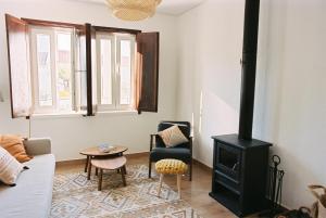a living room with a stove and a couch at Casa das Termas - Cabeço de Vide in Cabeço de Vide
