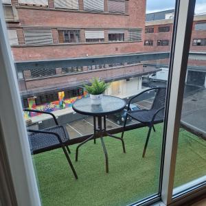Solace Apartment, Oslo Downtown في أوسلو: طاولة وكراسي على شرفة مع نافذة