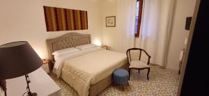 - une petite chambre avec un lit et une chaise dans l'établissement Casa Mary, à Giardini Naxos