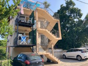 a building with stairs and cars parked in front of it at Budva, Jaz, apartmani DIF in Budva