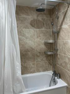 a bathroom with a shower and a tub with a shower curtain at Modern 3 Bed House for 6 guests in Nevendon