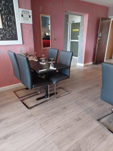 a dining room with a table and black chairs at The Watling Inn in Nuneaton