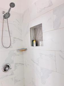 a bathroom with a shower with white marble tiles at The Penthouse in Cincinnati