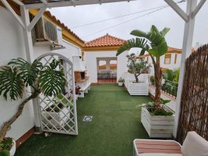 un patio de una casa con césped verde en Atico con gran terraza y barbacoa en Zahara, en Zahara de los Atunes