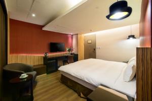 Habitación de hotel con cama y escritorio en Stay Hotel - Taichung Yizhong, en Taichung