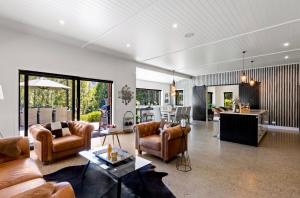 a living room with a couch and chairs and a kitchen at Queenstown Snowland Estate in Arrowtown