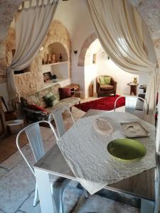 sala de estar con mesa y sillas en Trullo Colori d'Itria, en Ostuni