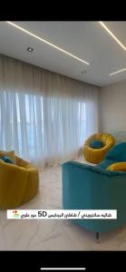a room with two yellow chairs and a bed at لافونتين بردايس in Durat  Alarous