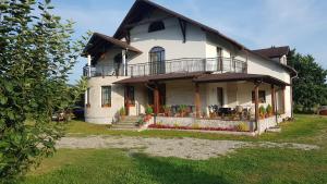 uma casa grande com uma varanda ao lado em Natura Chalet em Gîlgău