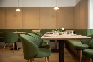una sala da pranzo con tavoli e sedie verdi di Apollo AchtQuartier Das Hotel am Mondsee a Mondsee
