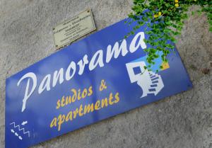 a blue sign on the side of a building at Panorama Studios & Apartments in Myrties