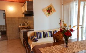 a kitchen with a table and a couch in a room at Guesthouse Marija II in Lopar