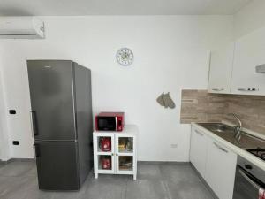 a kitchen with a refrigerator and a microwave at Moderno e Confortevole Appartamento, Wi-Fi e Parcheggio Gratuito in Sanluri +38 photos