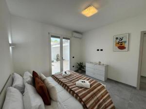 Moderno e Confortevole Appartamento, Wi-Fi e Parcheggio Gratuito في Sanluri: غرفة معيشة مع أريكة بيضاء وسرير