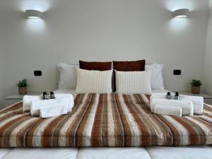 Moderno e Confortevole Appartamento, Wi-Fi e Parcheggio Gratuito في Sanluri: سرير كبير عليه طاولتين