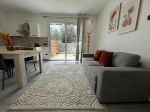 a living room with a couch and a table and a kitchen at Moderno e Confortevole Appartamento, Wi-Fi e Parcheggio Gratuito in Sanluri