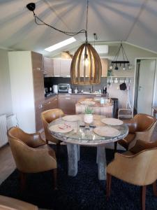 uma sala de jantar com mesa e cadeiras e uma cozinha em Chalet op Zee in Wervershoof mit Seeblick und Terrasse mit eigenen Zugang zum Wasser em Wervershoof