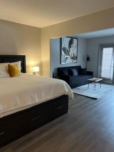 - une chambre avec un grand lit et un canapé dans l'établissement Valley Vista Retreat - Luxe Studio - Top Floor Serenity - Romantic Getaway - Heated Pool Haven, à Shanty Bay