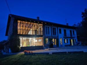 a large building with large windows at night at B&B Il vecchio pero in Capriglio