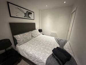 ein Schlafzimmer mit einem Bett mit einer schwarzen Tasche darauf in der Unterkunft Modern Flat in Camden Town in London