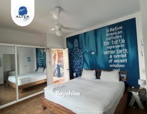 um quarto com uma cama com uma parede azul em Bayahibe Village Inn em Bayahibe