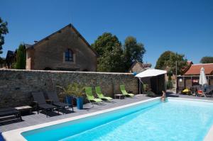 a swimming pool with chairs and a person in the water at La Ligne in Angles-sur-lʼAnglin