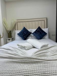 a bed with blue and white pillows on it at 1 Bedroom Luxury Flat in Kensington in London