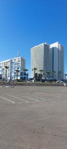 um parque de estacionamento vazio em frente a edifícios altos em Suite on the Bat Yam seashore em Bat Yam